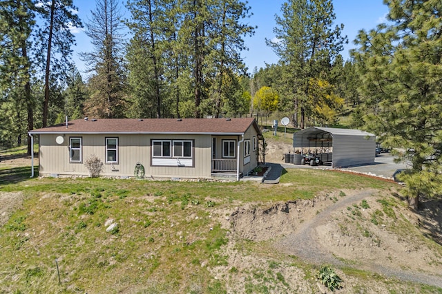 view of front of house with a front yard and a detached carport