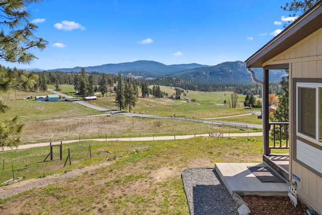 view of yard with a rural view and a mountain view