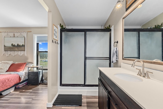 bathroom featuring wood finished floors, vanity, ensuite bath, and a stall shower
