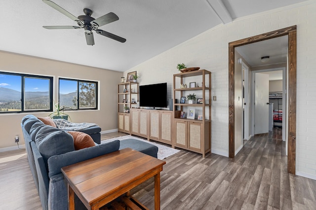 living area featuring wood finished floors, vaulted ceiling with beams, and baseboards