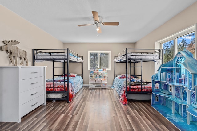 bedroom featuring wood finished floors, baseboards, a ceiling fan, and multiple windows