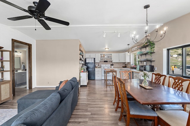 dining room featuring track lighting, baseboards, wood finished floors, and ceiling fan with notable chandelier