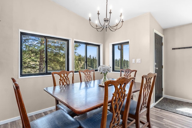 dining room featuring wood finished floors, a chandelier, and baseboards