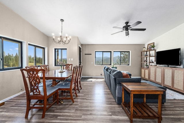 dining room featuring dark wood-type flooring, ceiling fan with notable chandelier, and baseboards
