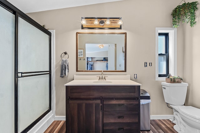 bathroom featuring vanity, toilet, an enclosed shower, baseboards, and wood finished floors