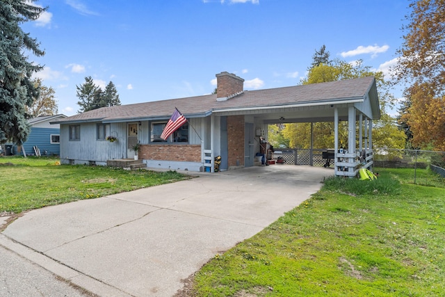 ranch-style home with driveway, an attached carport, a chimney, fence, and a front lawn