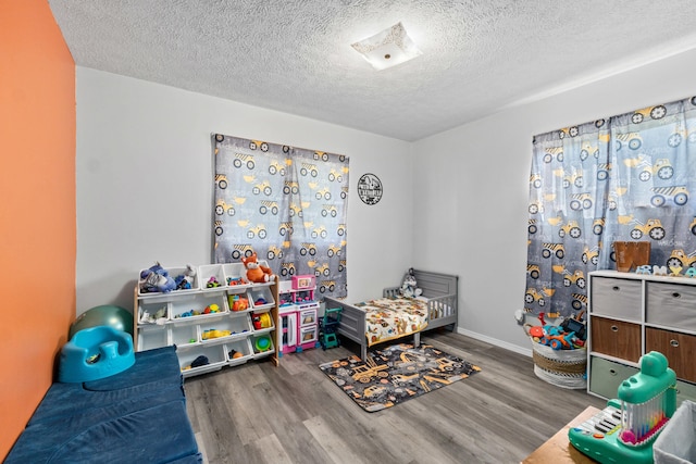 playroom featuring a textured ceiling and wood finished floors