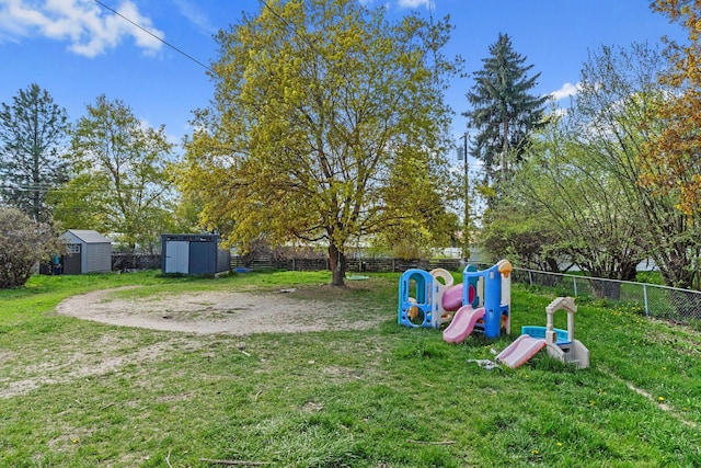 view of yard with fence, a storage unit, a playground, and an outdoor structure