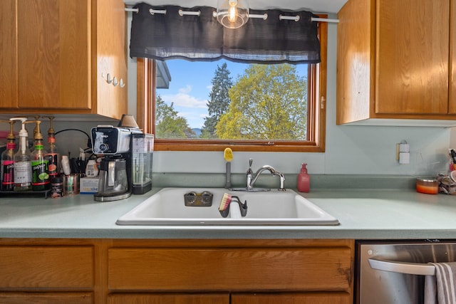 kitchen with a sink, dishwasher, brown cabinets, and light countertops