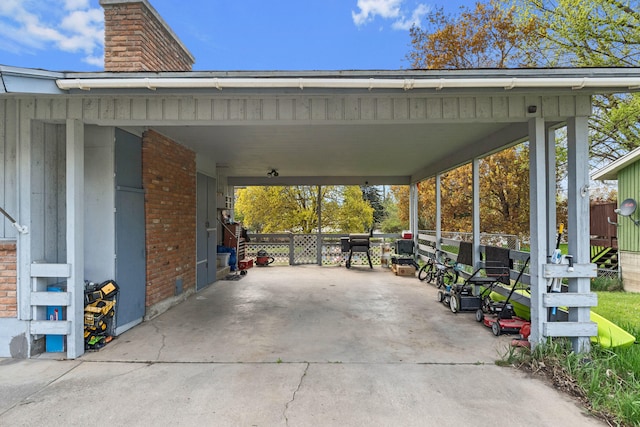 view of parking / parking lot with concrete driveway and an attached carport