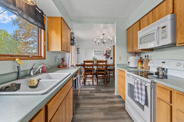 kitchen featuring dark wood finished floors, white appliances, a chandelier, light countertops, and a sink