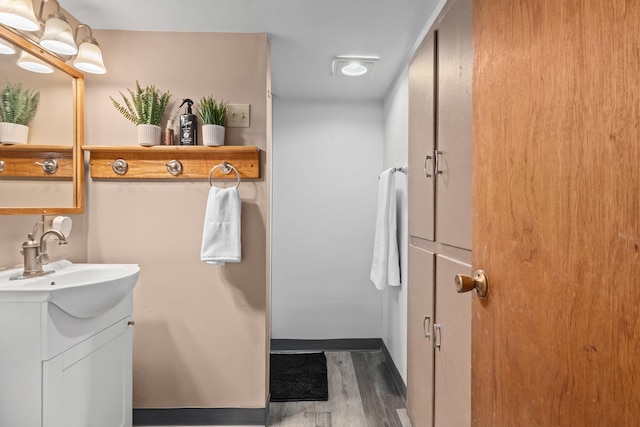 bathroom featuring wood finished floors, vanity, and baseboards