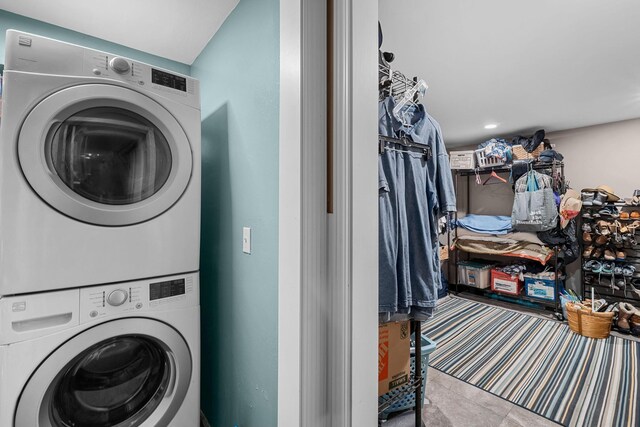 clothes washing area featuring stacked washing maching and dryer