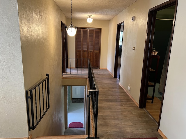 hallway featuring dark wood-type flooring and a textured ceiling