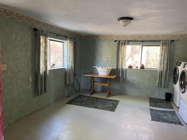 clothes washing area with a textured ceiling and washer and clothes dryer