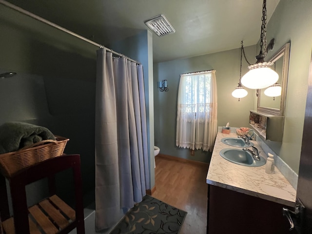 bathroom featuring hardwood / wood-style floors, toilet, vanity, and a shower with shower curtain