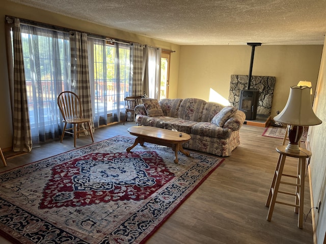 living room with a wood stove, hardwood / wood-style floors, and a textured ceiling