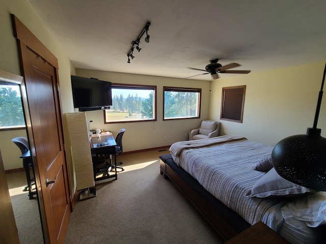 bedroom featuring ceiling fan, light colored carpet, and rail lighting