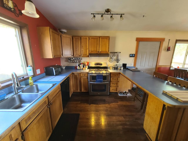 kitchen with black dishwasher, hanging light fixtures, sink, kitchen peninsula, and range with two ovens