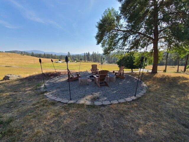 view of yard with a mountain view, a rural view, and a fire pit