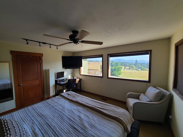 bedroom featuring rail lighting and ceiling fan