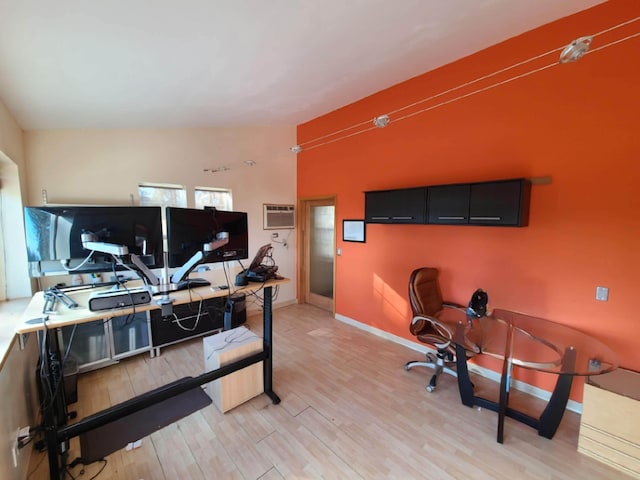 office with a wall mounted air conditioner and light hardwood / wood-style flooring