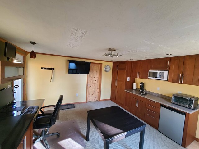 kitchen with light colored carpet, pendant lighting, stainless steel fridge, and ornamental molding