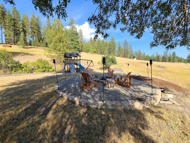 view of yard with an outdoor fire pit and a playground