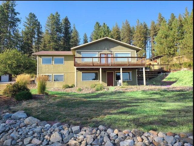 view of front of house featuring a wooden deck and a front lawn