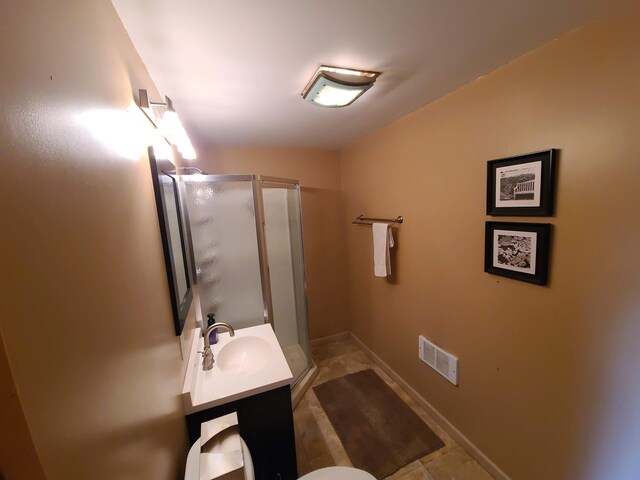 bathroom with a shower with shower door and vanity