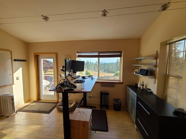 office space featuring radiator heating unit, light hardwood / wood-style floors, and lofted ceiling