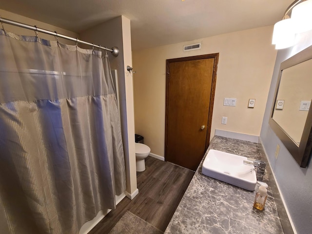 bathroom featuring a shower with curtain, hardwood / wood-style floors, toilet, and vanity