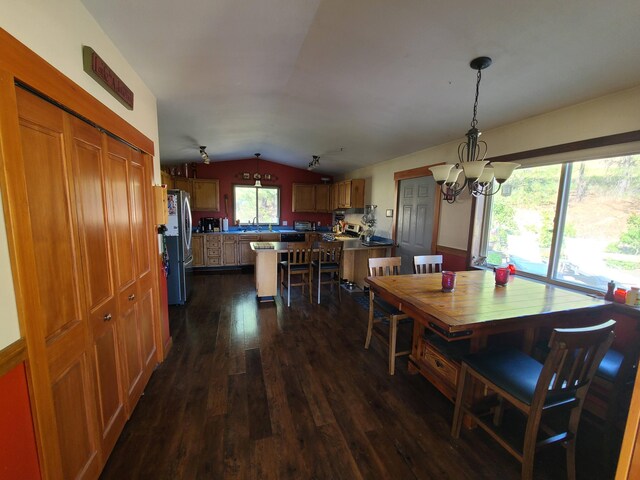 dining room with dark hardwood / wood-style floors, an inviting chandelier, and vaulted ceiling