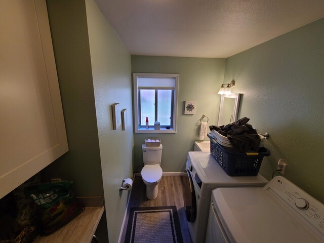 clothes washing area with hardwood / wood-style floors and washer and dryer