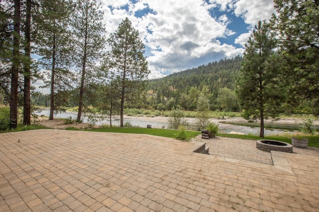 view of patio / terrace featuring an outdoor fire pit and a water view