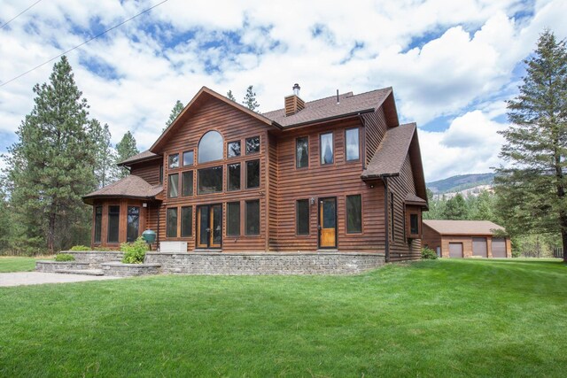 back of house with a garage and a yard