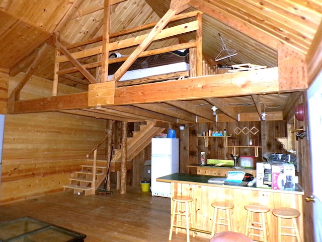 3121 Fifteen Mile Creek Rd, Kettle Falls, WA 99141 - kitchen featuring wooden walls, freestanding refrigerator, vaulted ceiling, and wood finished floors