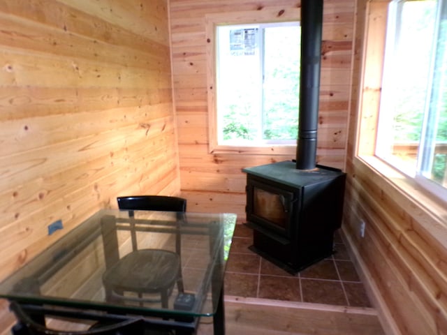 room details featuring wooden walls and a wood stove