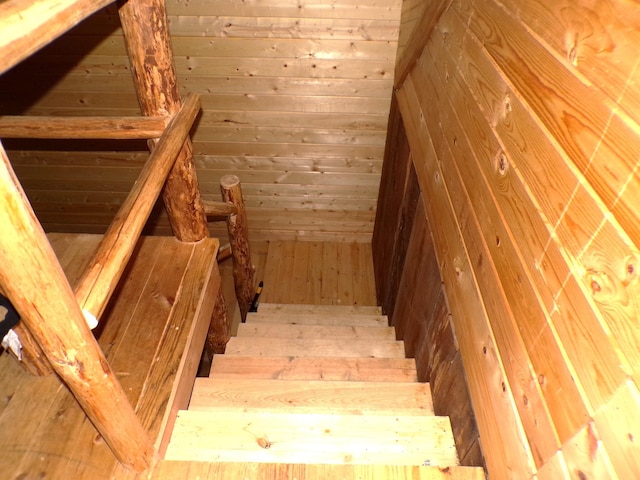 stairs featuring wood walls and hardwood / wood-style floors