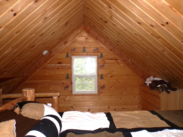 unfurnished bedroom featuring wooden walls and vaulted ceiling