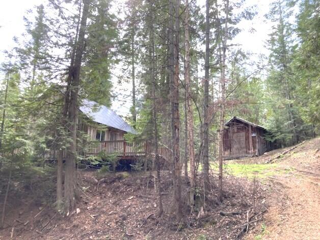3121 Fifteen Mile Creek Rd, Kettle Falls, WA 99141 - view of yard with a forest view, a deck, and an outdoor structure