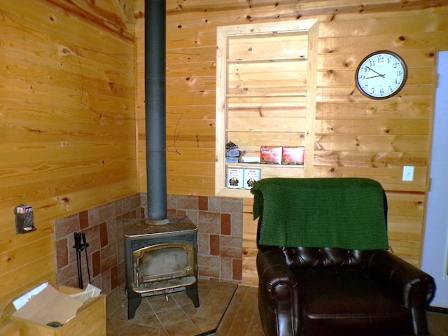 living room featuring wooden walls and a wood stove