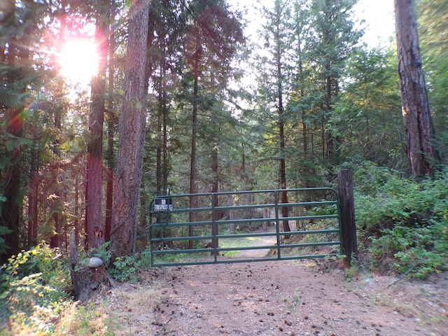 view of gate with a view of trees