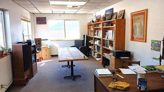 carpeted office space featuring a paneled ceiling