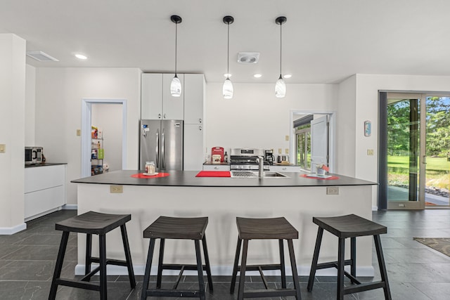 250 Hogans Way, Chewelah, WA 99109 - kitchen featuring freestanding refrigerator, white cabinetry, modern cabinets, dark countertops, and a kitchen breakfast bar
