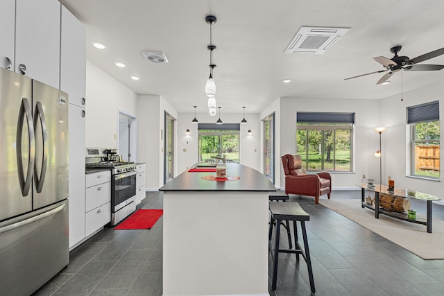 250 Hogans Way, Chewelah, WA 99109 - kitchen featuring stainless steel appliances, white cabinets, dark countertops, open floor plan, and recessed lighting
