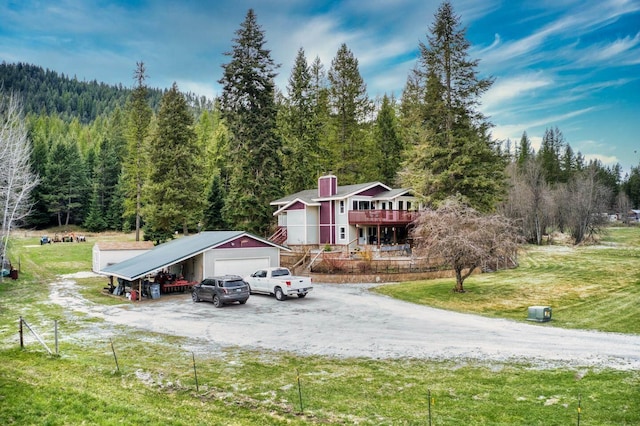 view of front of house with a garage, an outbuilding, a front yard, and a carport