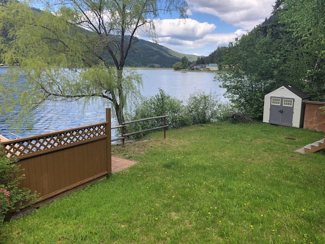 2952 Deep Lake Boundary Rd, Colville, WA 99114 - view of green lawn featuring a water and mountain view, a shed, and an outbuilding