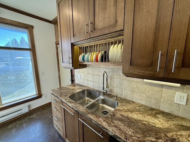 kitchen featuring sink, tasteful backsplash, a baseboard radiator, ornamental molding, and dark stone counters