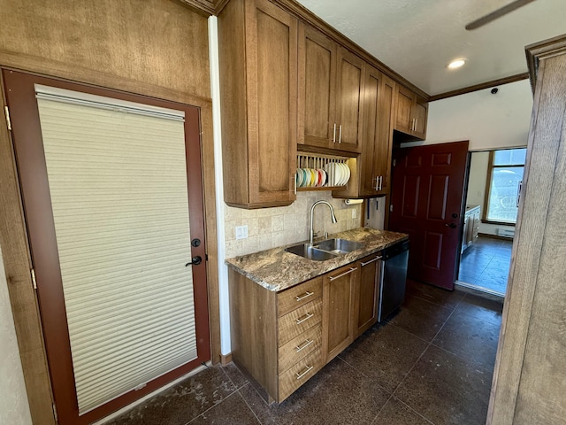 kitchen featuring dishwasher, sink, decorative backsplash, dark stone counters, and ornamental molding